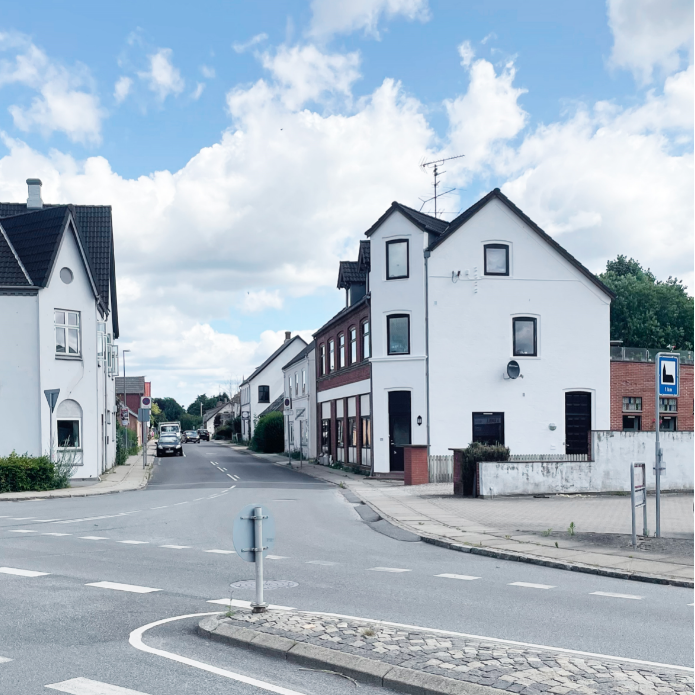 Huset efter renoveringen. Den hvide farve skaber kontrast til de synlige mursten, som er tilbage på siden af huset. Bemærk også, at den hvide originale stribe, hvor der engang var et navneskilt, er kommet tilbage.