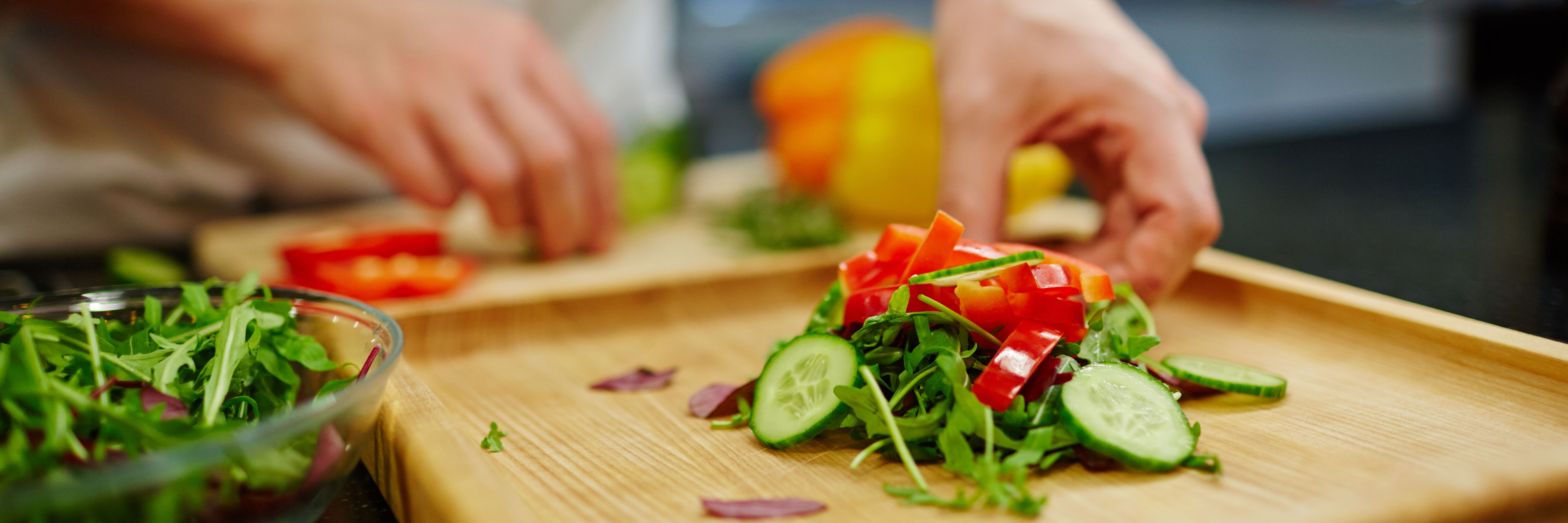 Kok som snitter salat og forskellige slags grøntsager