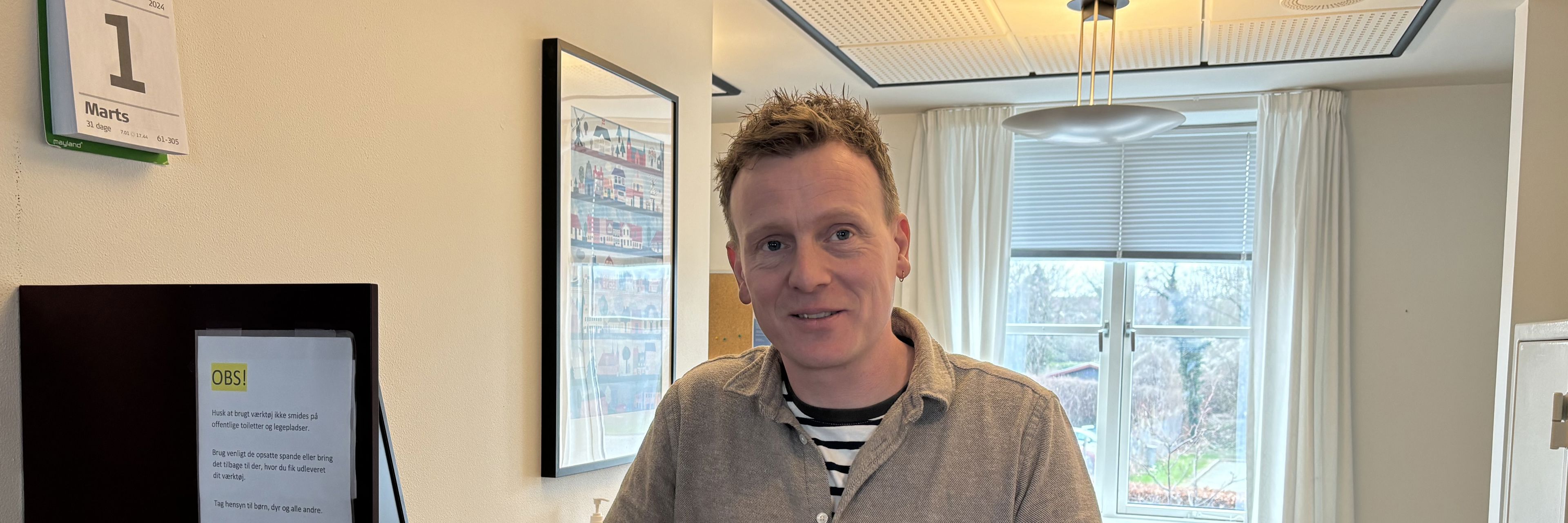 Mand står bag skranke.