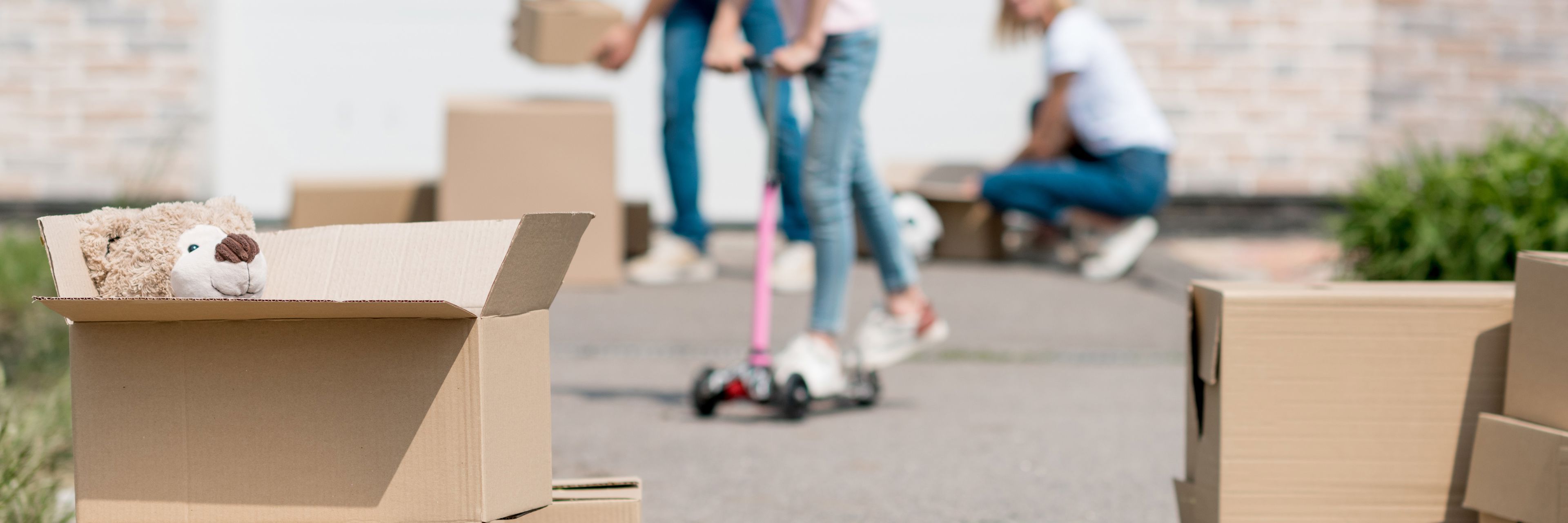 Familie med flyttekasser i indkørsel