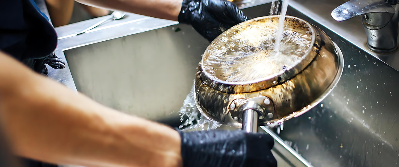 Person vasker en pande under en vandhane