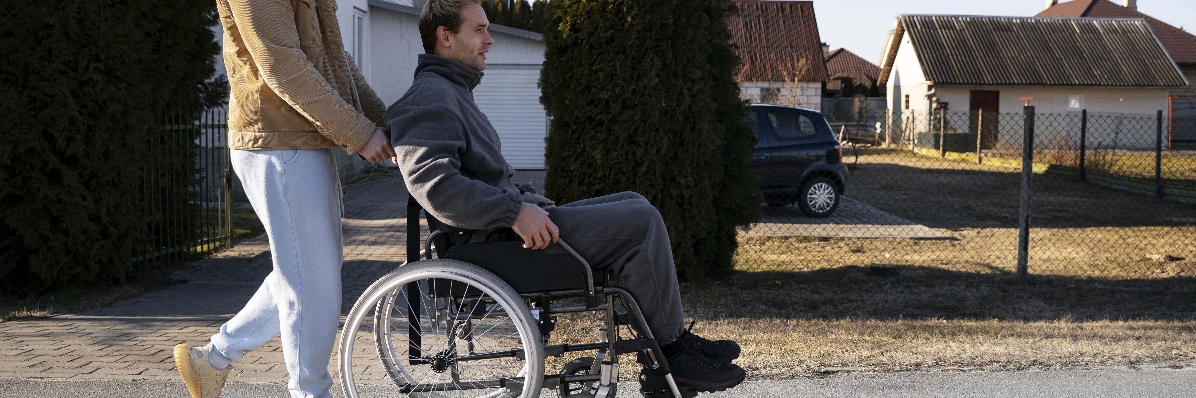 Mand i kørestol med ledsager