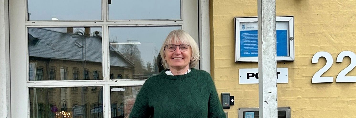 Kvinde står foran indgangsdør